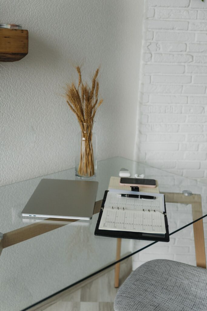 Lugar de trabajo con portatil y cuaderno abierto con boligrafo